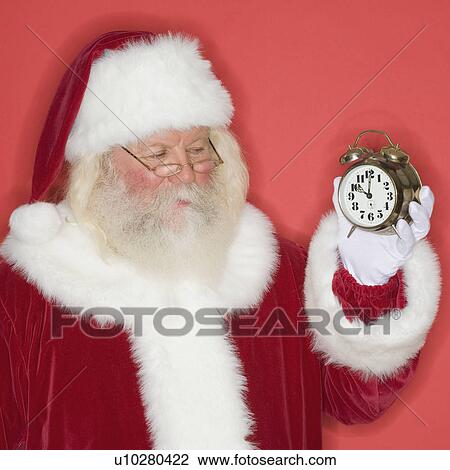Santa Claus holding alarm clock View Large Photo Image Stock Image - Santa Claus holding alarm clock. Fotosearch