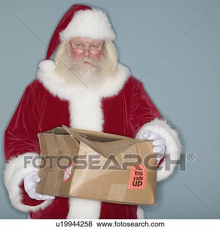 Stock Photo - Santa Claus holding damaged box. Fotosearch