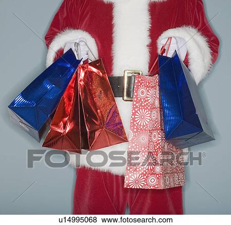Santa Claus holding shopping bags View Large Photo Image Stock Photo - Santa Claus holding shopping bags. Fotosearch