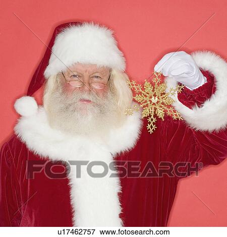 Santa Claus holding snowflake Christmas ornament View Large Photo Image Stock Photo - Santa Claus holding snowflake Christmas ornament. Fotosearch