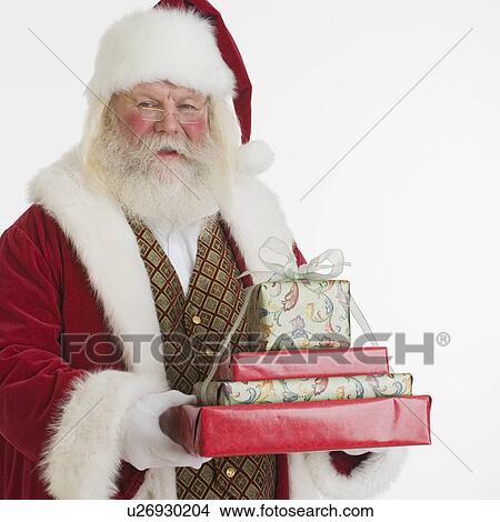 Picture - Santa Claus holding stack of gifts. Fotosearch