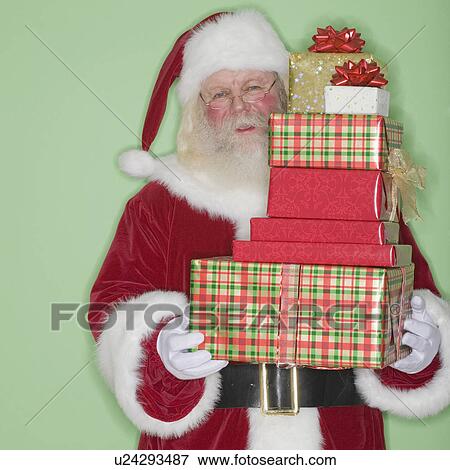 Santa Claus holding stack of gifts View Large Photo Image Stock Photo - Santa Claus holding stack of gifts. Fotosearch