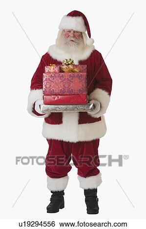 Stock Photograph - Santa Claus holding stack of gifts. Fotosearch