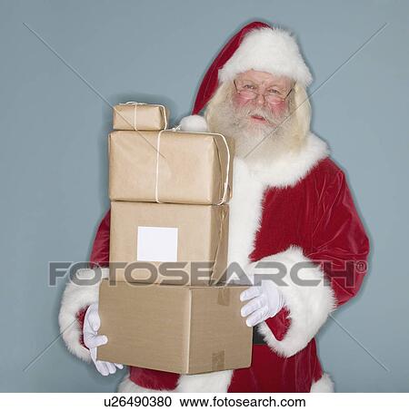 Stock Image - Santa Claus holding stack of packages. Fotosearch
