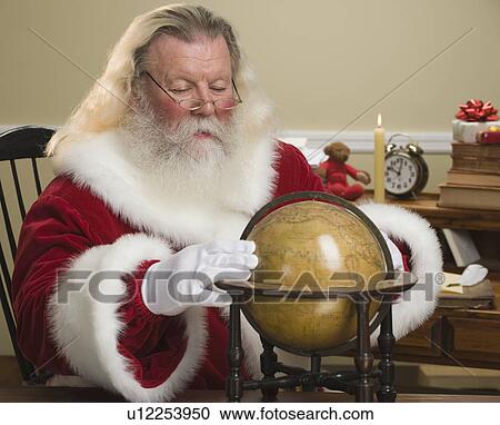 Santa Claus looking at globe View Large Photo Image Stock Image - Santa Claus looking at globe. Fotosearch