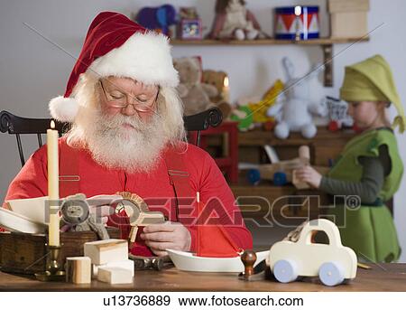Santa Claus looking at toys View Large Photo Image Stock Photo - Santa Claus looking at toys. Fotosearch
