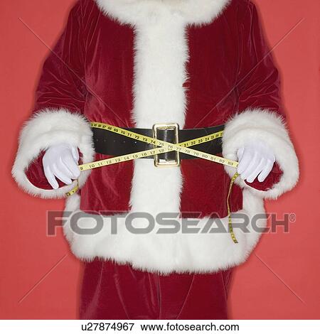 Stock Photo - Santa Claus measuring waist with tape measure. Fotosearch