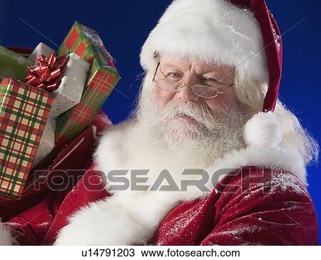 Santa Claus next to bag of toys View Large Photo Image Stock Image - Santa Claus next to bag of toys. Fotosearch