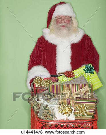 Stock Photo - Santa Claus pushing shopping cart of gifts. Fotosearch