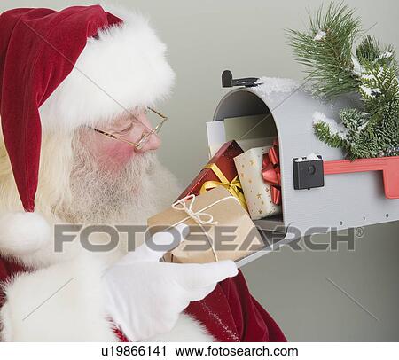 Santa Claus putting gifts in mailbox View Large Photo Image Stock Image - Santa Claus putting gifts in mailbox. Fotosearch