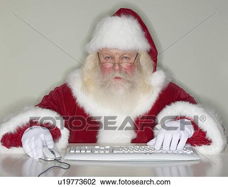 Stock Image - Santa Claus typing on computer. Fotosearch