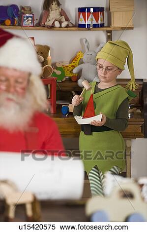 Stock Photography - Santa Claus’s elf making toy. Fotosearch