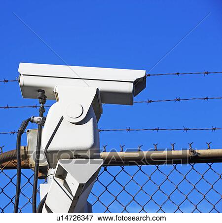Security camera on fence View Large Photo Image Stock Photo - Security camera on fence. Fotosearch