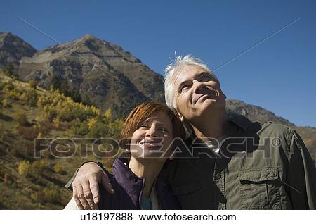 Stock Photo - Senior couple hugging outdoors, Utah, United States. Fotosearch