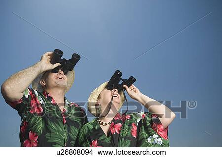 Picture - Senior couple looking through binoculars. Fotosearch