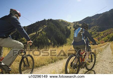 Stock Photo - Senior couple riding mountain bikes, Utah, United States. Fotosearch