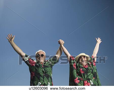 Stock Photograph - Senior couple with arms raised. Fotosearch
