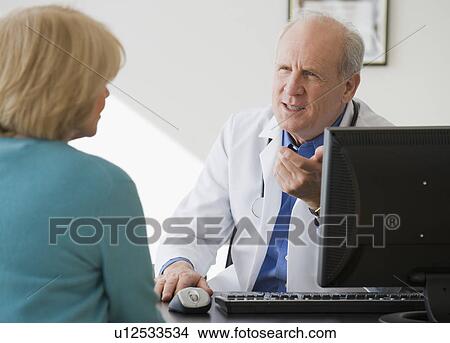 Senior male doctor talking to patient View Large Photo Image Picture - Senior male doctor talking to patient. Fotosearch