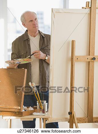 Senior man painting on easel View Large Photo Image Stock Photograph - Senior man painting on easel. Fotosearch