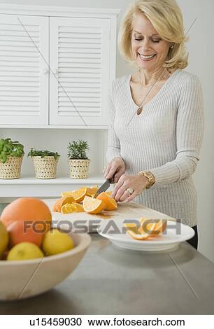 Senior woman cutting oranges View Large Photo Image Stock Image - Senior woman cutting oranges. Fotosearch