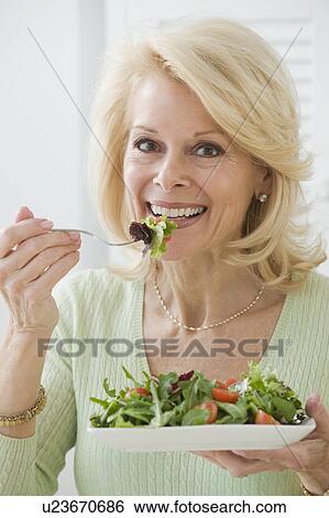 Senior woman eating salad View Large Photo Image Stock Photograph - Senior woman eating salad. Fotosearch