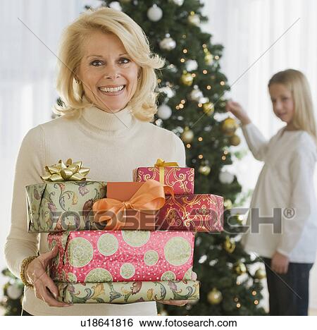 Senior woman holding stack of Christmas gifts View Large Photo Image Stock Photograph - Senior woman holding stack of Christmas gifts. Fotosearch
