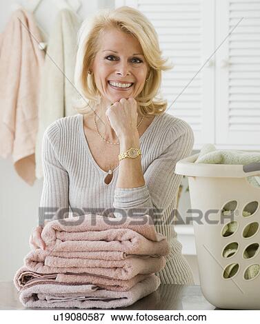 Senior woman leaning on folded towels View Large Photo Image Stock Photo - Senior woman leaning on folded towels. Fotosearch