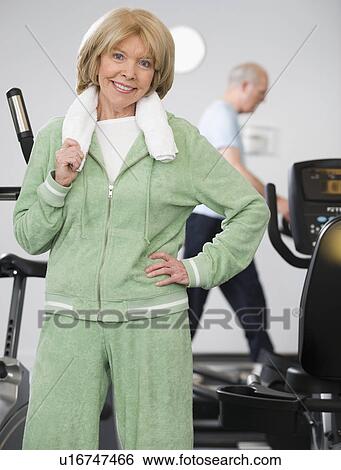 Senior woman next to exercise machines View Large Photo Image Stock Photograph - Senior woman next to exercise machines. Fotosearch