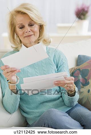Stock Photography - Senior woman reading mail. Fotosearch