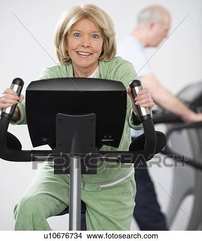 Senior woman riding on exercise machine View Large Photo Image Picture - Senior woman riding on exercise machine. Fotosearch