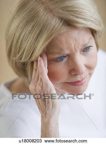 Senior woman rubbing temple View Large Photo Image Stock Image - Senior woman rubbing temple. Fotosearch