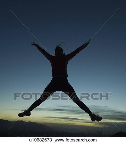 Stock Image - Silhouette of women jumping, Salt Flats, Utah, United States. Fotosearch