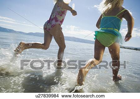 Picture - Sisters running in water, Utah, United States. Fotosearch