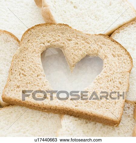 Stock Image - Slice of bread with heart in middle. Fotosearch