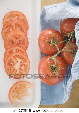 Stock Photograph - Sliced tomatoes on cutting board. Fotosearch