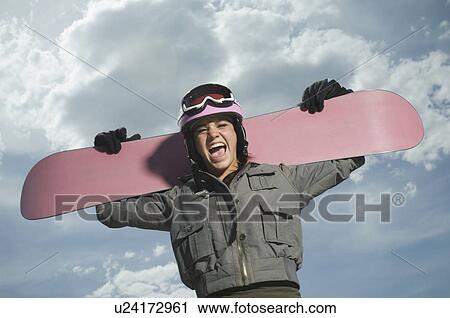 Stock Image - Snowboarder holding board on shoulders. Fotosearch