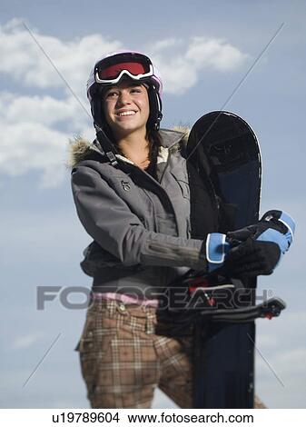 Picture - Snowboarder holding board. Fotosearch