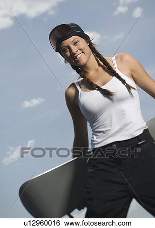 Snowboarder holding board View Large Photo Image Stock Photograph - Snowboarder holding board. Fotosearch