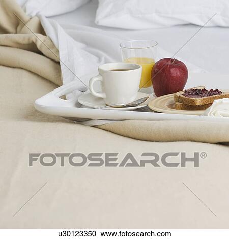 Stock Image - Still life of breakfast tray on bed. Fotosearch
