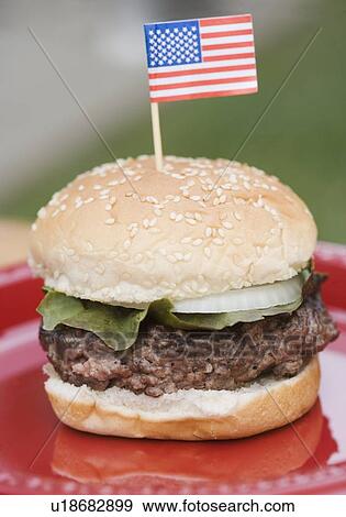 Stock Photo - Still life of hamburger with small US flag. Fotosearch