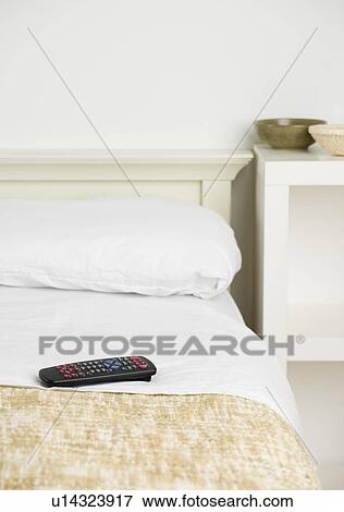 Stock Photo - Still life of remote control on bed. Fotosearch