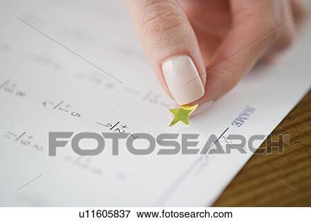Teacher affixing gold star to math worksheet View Large Photo Image Stock Photo - Teacher affixing gold star to math worksheet. Fotosearch