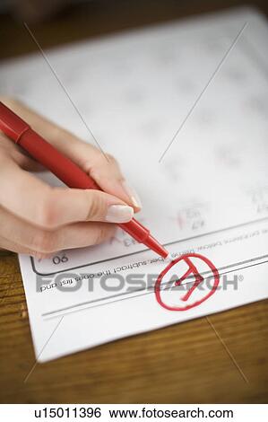 Stock Photograph - Teacher writing F grade on worksheet. Fotosearch