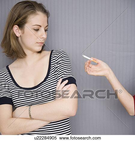 Teenage girl looking at cigarette in friend’s hand View Large Photo Image Stock Photography - Teenage girl looking at cigarette in friend’s hand. Fotosearch