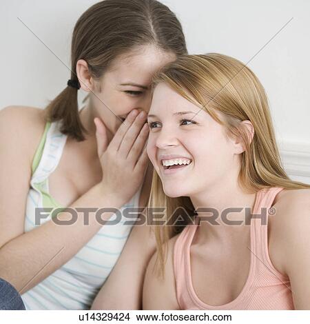 Picture - Teenage girl telling secret. Fotosearch