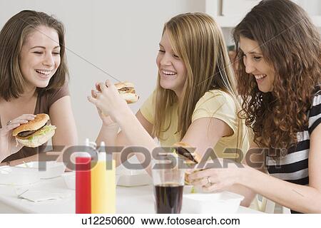 Teenage girls eating hamburgers View Large Photo Image Stock Image - Teenage girls eating hamburgers. Fotosearch