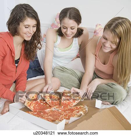Teenage girls eating pizza on bed View Large Photo Image Stock Image - Teenage girls eating pizza on bed. Fotosearch