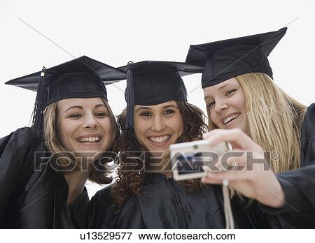 Teenage girls taking own photograph on graduation day View Large Photo Image Stock Photo - Teenage girls taking own photograph on graduation day. Fotosearch