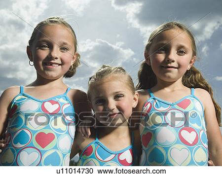 Three young sisters hugging View Large Photo Image Stock Image - Three young sisters hugging. Fotosearch