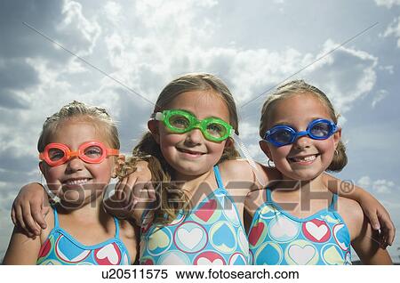 Three young sisters wearing swimming goggles View Large Photo Image Stock Photography - Three young sisters wearing swimming goggles. Fotosearch